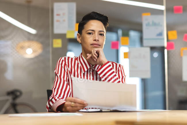 Thoughtful caucasian female business creative brainstorming and writing memo notes on glass wall. independent creative business people working at a modern office. — Stock Photo