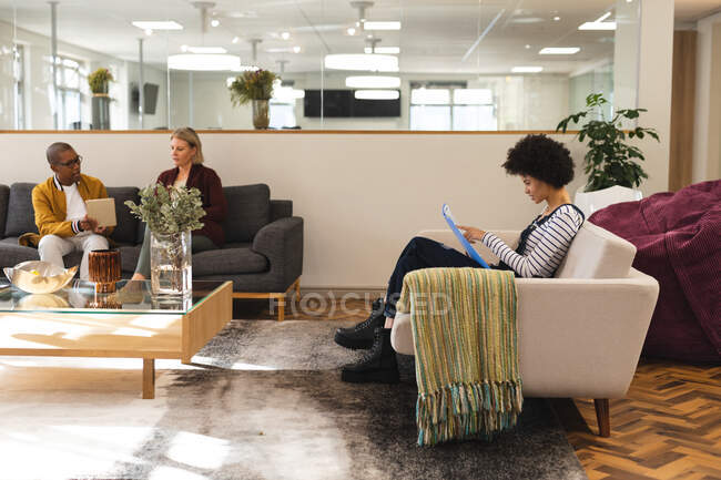 Diverse male and female colleagues working together in workplace lounge area. working in creative business at a modern office. — Stock Photo