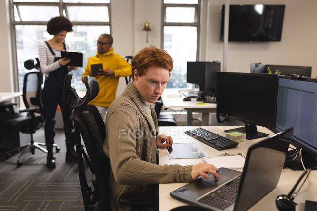 Homem branco criativo no trabalho, sentado na mesa, usando laptop. trabalhando em negócios criativos em um escritório moderno. — Fotografia de Stock