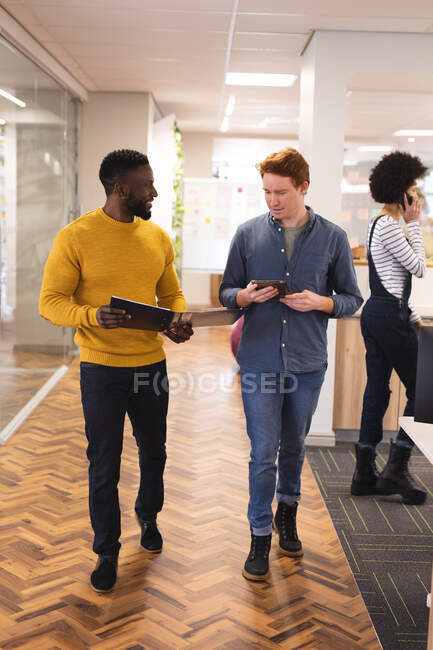 Diversos colegas masculinos y femeninos trabajando juntos usando tableta. trabajar en un negocio creativo en una oficina moderna. - foto de stock
