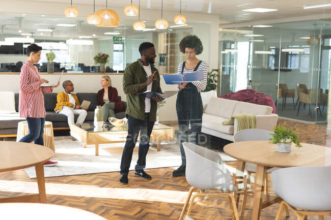 Разнообразные коллеги-мужчины и женщины, работающие вместе в зоне отдыха на рабочем месте. работа в творческом бизнесе в современном офисе. — стоковое фото