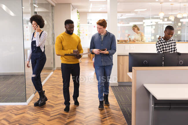Diversos colegas masculinos y femeninos trabajando juntos usando tableta. trabajar en un negocio creativo en una oficina moderna. - foto de stock