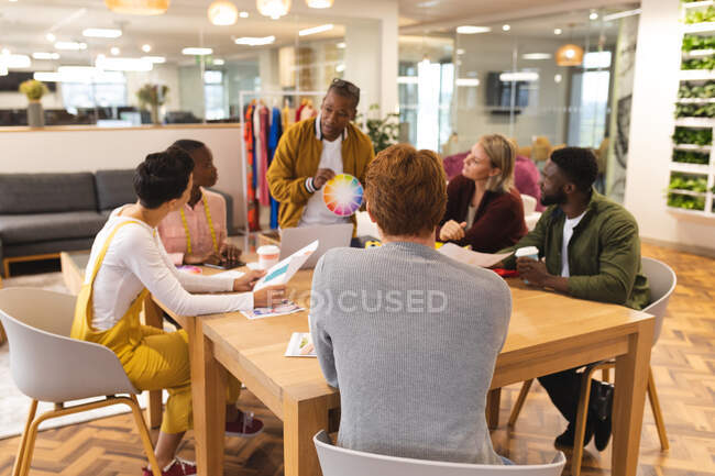 Diversos colegas do sexo masculino e feminino trabalham juntos, discutindo em reunião casual. trabalhando em negócios criativos em um escritório moderno. — Fotografia de Stock