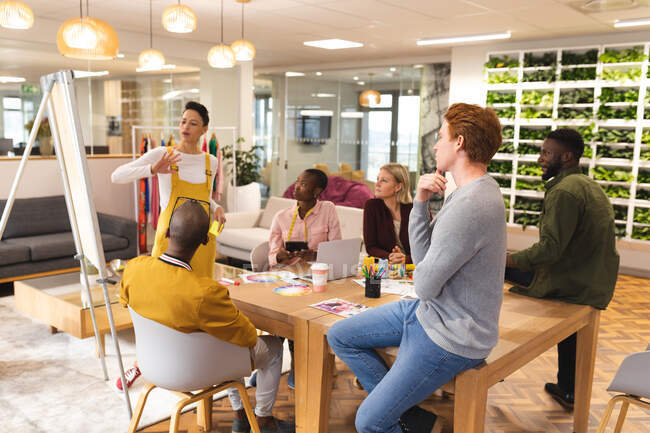 Diverse männliche und weibliche Kollegen arbeiten zusammen und diskutieren in lockerer Runde. Arbeit im kreativen Geschäft in einem modernen Büro. — Stockfoto