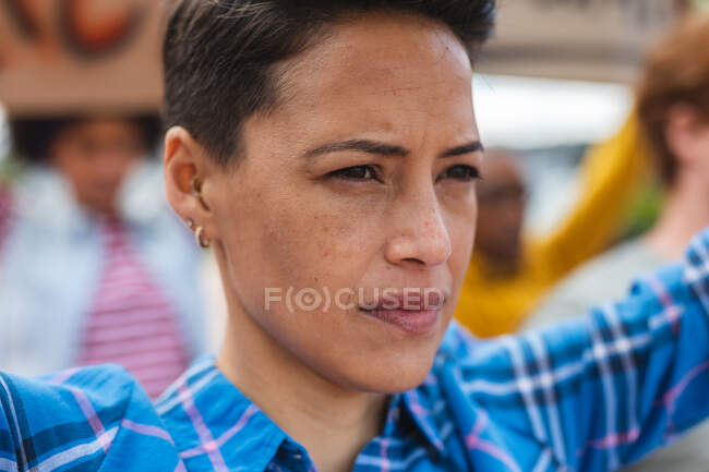 Donna di razza mista che tiene cartello alla marcia di protesta. manifestanti per la parità di diritti e la giustizia in marcia dimostrativa. — Foto stock