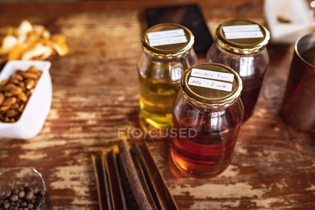 Close up view of multiple ingredients on a wooden table for gin production at gin distillery. alcohol production and filtration concept. — Stock Photo