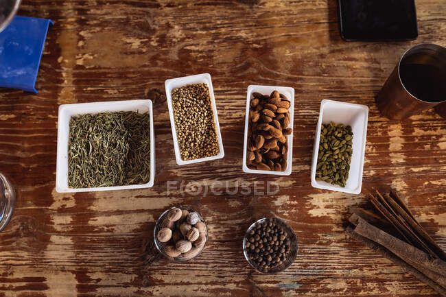 Overhead view of multiple ingredients on a wooden table for for gin production at gin distillery. alcohol production and filtration concept — Stock Photo