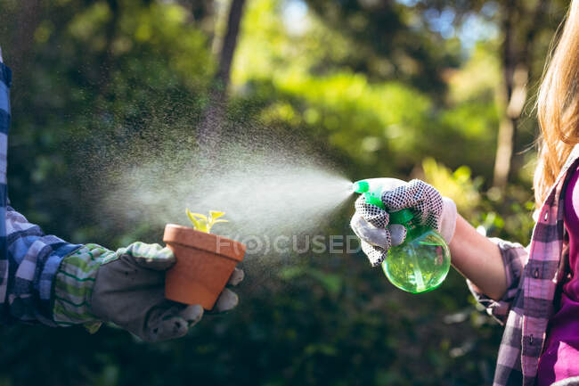 Hands of grandfather and granddaughter gardening, watering plants. family time, active and healthy retirement lifestyle at home and garden. — Stock Photo