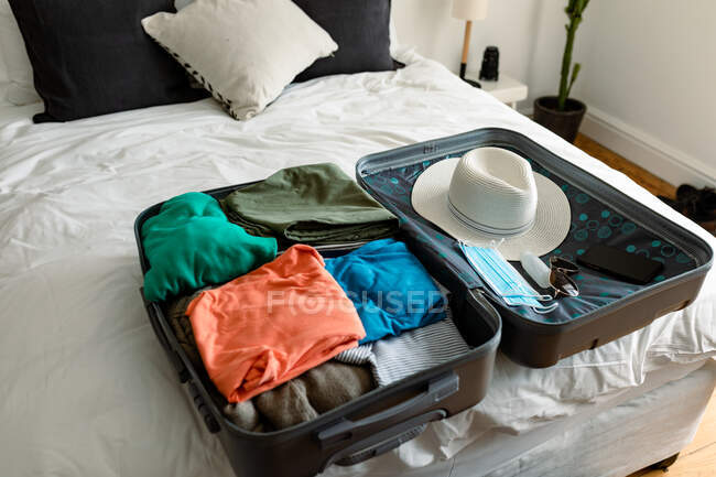 Koffer, Smartphone mit Mundschutz und Desinfektionsflüssigkeit. Urlaubs- und Reisevorbereitungen während der Covid 19 Pandemie. — Stockfoto