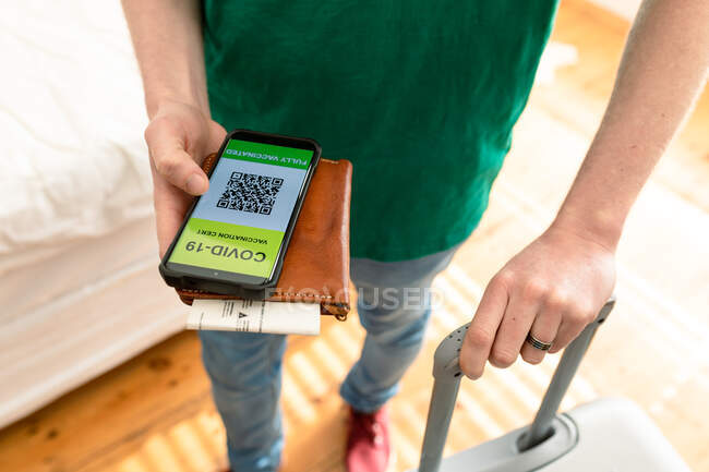 Man holding smartphone with covid 19 vaccine passport. holiday and travel preparation during covid 19 pandemic. — Stock Photo