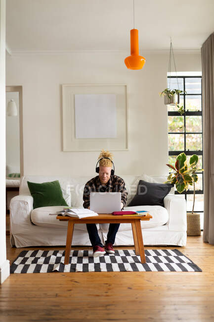 Африканский американец Альбинос с дредами работает из дома и делает видеозвонок на ноутбуке. удаленная работа с использованием технологии на дому. — стоковое фото