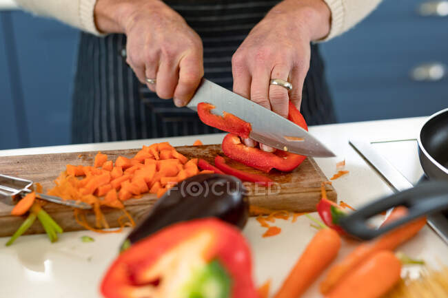 Close up de mulher caucasiana sênior na cozinha vestindo avental cozinhar. estilo de vida saudável e ativo em casa. — Fotografia de Stock