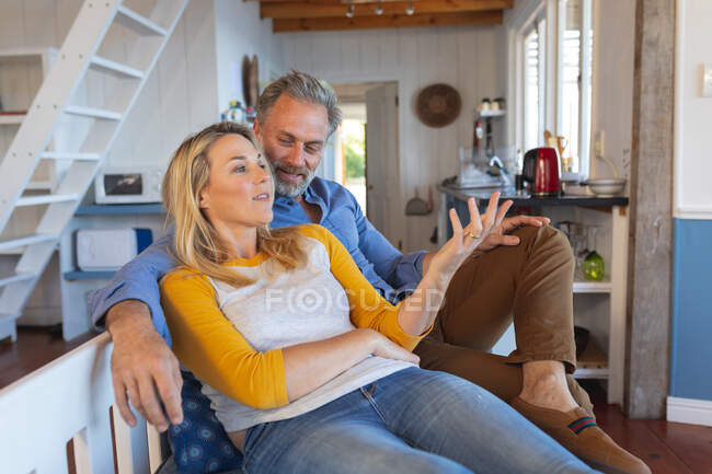 Щаслива біла зріла пара сидить і розмовляє на кухні. насолоджуючись дозвіллям вдома . — стокове фото