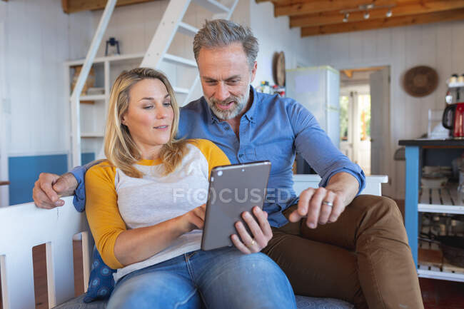 Feliz casal maduro caucasiano fazendo videochamada na cozinha. desfrutar de tempo de lazer em casa. — Fotografia de Stock