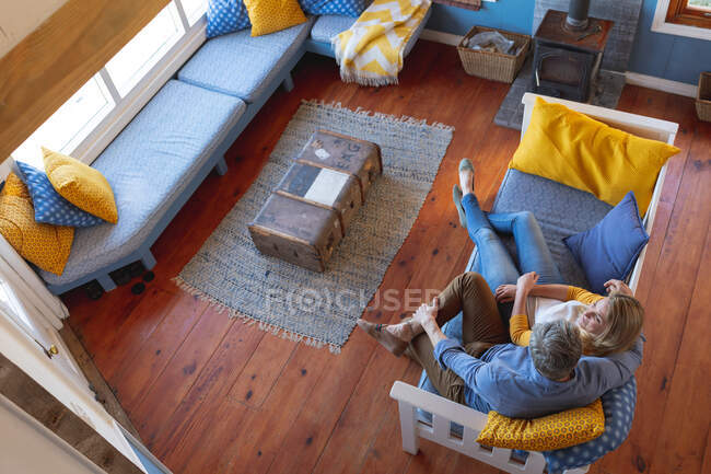 Visão superior sobre casal maduro caucasiano passar tempo na sala de estar. desfrutar de tempo de lazer em casa. — Fotografia de Stock