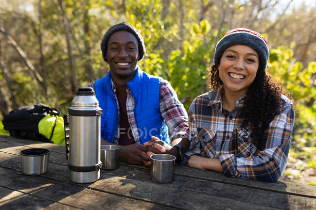 Vielseitiges Paar trinkt Kaffee und macht Pause vom Wandern in der Natur. gesunder, aktiver Lebensstil und Freizeit im Freien. — Stockfoto