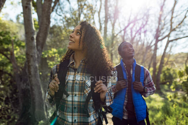 Glückliches, vielseitiges Paar mit Rucksack beim Wandern in der Natur. gesunder, aktiver Lebensstil und Freizeit im Freien. — Stockfoto
