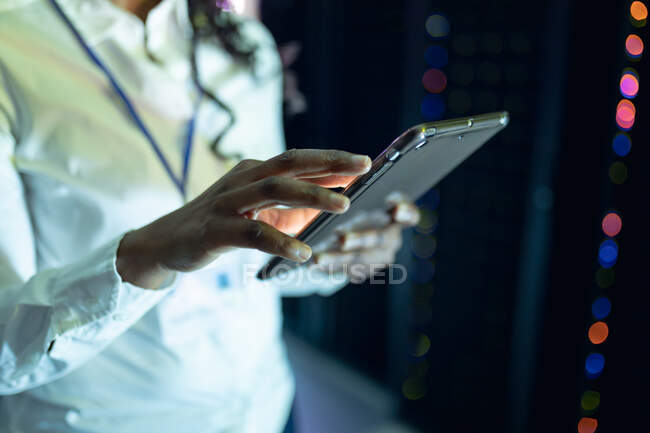 Closeup of female computer technician using tablet working in server room. digital information storage and communication network technology. — Stock Photo
