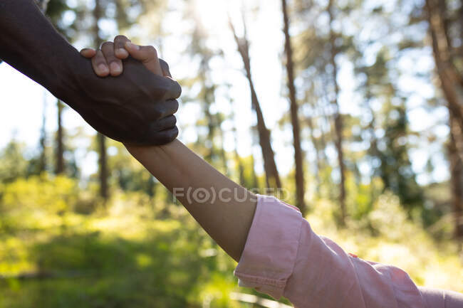 Close up of diverse couple holding hands in countryside. healthy, active outdoor lifestyle and leisure time. — Stock Photo
