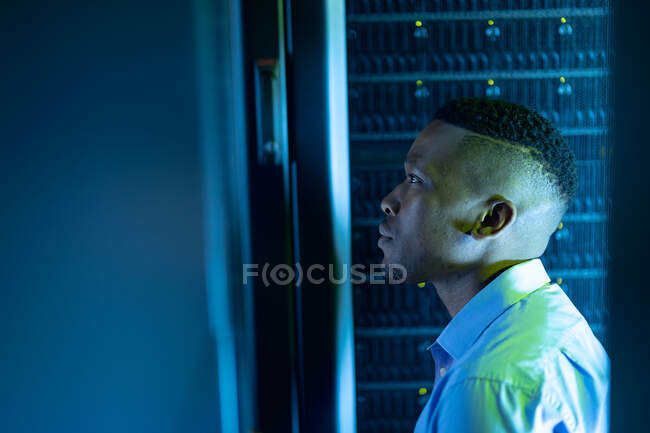 Técnico de informática afro-americano na sala de servidores. armazenamento digital de informações e tecnologia de rede de comunicação. — Fotografia de Stock