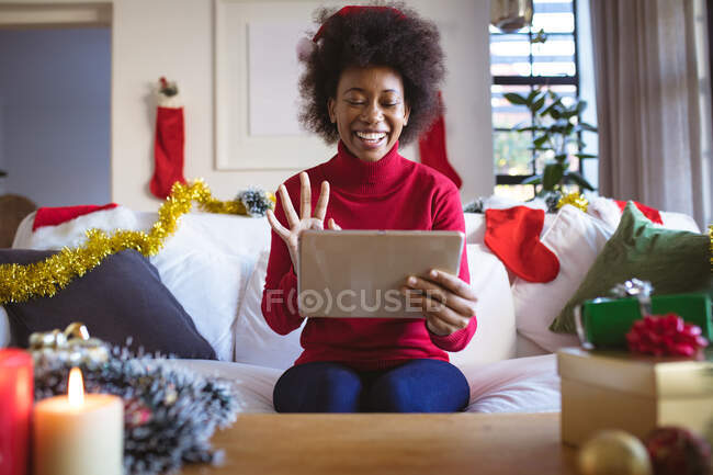 Щаслива афроамериканська жінка в капелюсі Санти робить відео-дзвінок на табличці christmas. кристами, свята і комунікаційні технології. — стокове фото