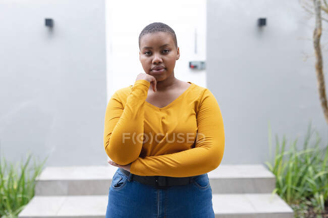 Портрет африканской американки плюс размер женщины стоящей на улице и смотрящей в камеру. образ жизни, отдых и проведение времени дома. — стоковое фото