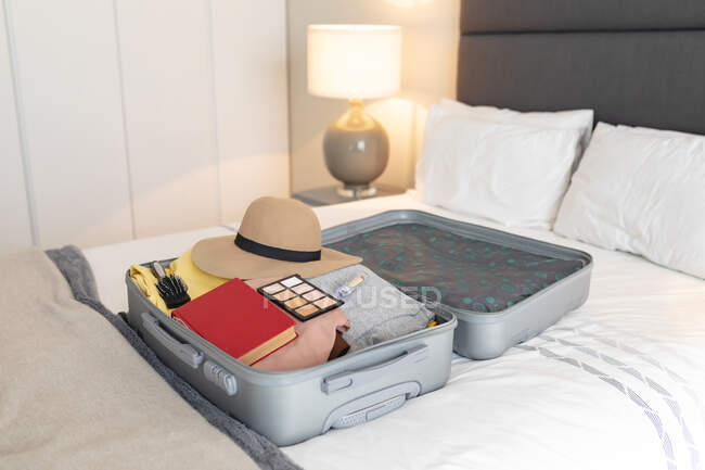 Suitcase with clothes and documents prepared for travel lying on bed. travel preparation during covid 19 pandemic. — Stock Photo