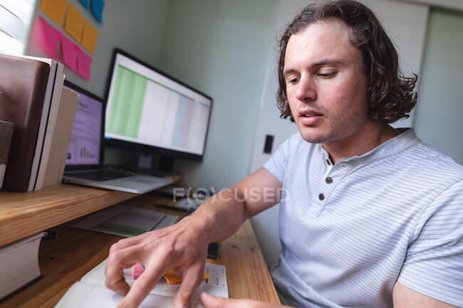 Кавказский человек с помощью компьютера работает из дома — стоковое фото