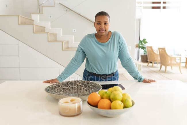 Africano americano plus size mulher de pé na cozinha. estilo de vida, lazer, passar tempo livre em casa. — Fotografia de Stock
