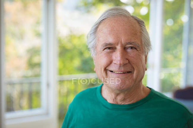 Portrait of smiling senior caucasian man looking at camera at home. spending time at home alone. — Stock Photo