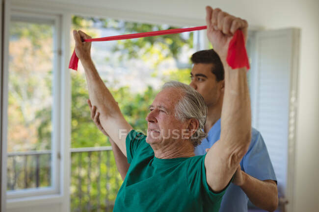 Biracial male physiotherapist treating back of senior male patient at clinic. senior healthcare and medical physiotherapy treatment. — Stock Photo