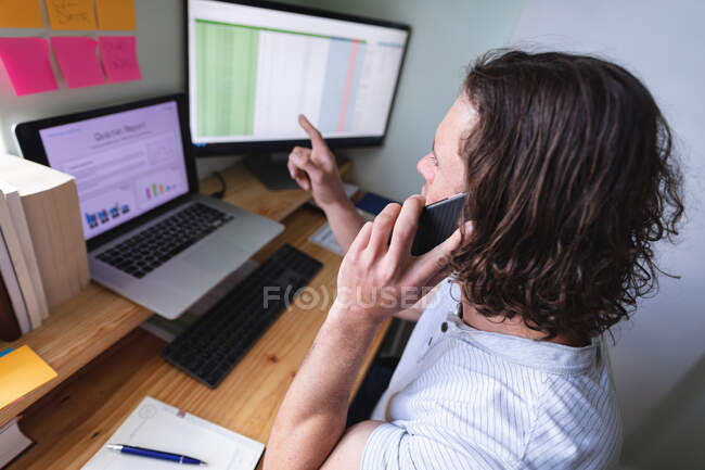 Caucasian disabled man sitting on wheelchair talking on smartphone while working from home. disability and handicap concept — Stock Photo