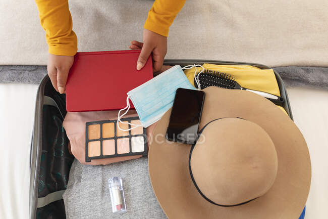 Hands of woman packing things in suitcase for travel. travel preparation during covid 19 pandemic. — Stock Photo