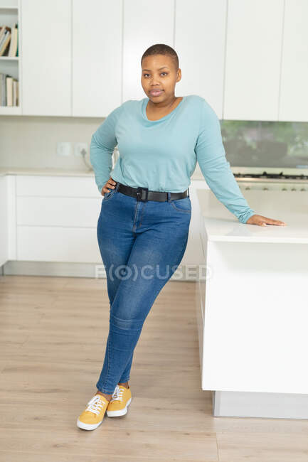 Afroamerikanische Plus-Size-Frau steht in der Küche. Lebensstil, Freizeit, Freizeit zu Hause verbringen. — Stockfoto