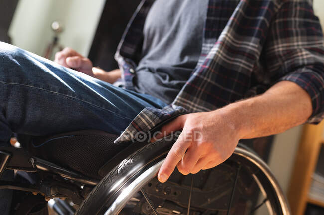 Sección media del hombre discapacitado sentado en silla de ruedas en casa. concepto de discapacidad y discapacidad - foto de stock