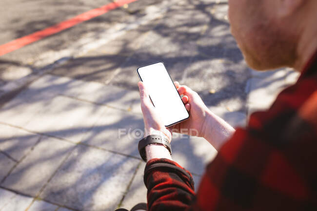 Albino-amerikanischer Mann mit Smartphone. digitaler Nomade unterwegs, unterwegs in der Stadt. — Stockfoto