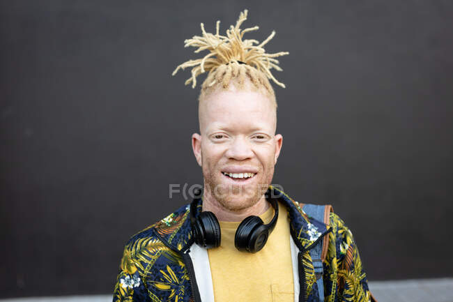 Retrato do homem americano africano albino com dreadlocks a olhar para a câmara. em movimento, fora e em torno da cidade. — Fotografia de Stock