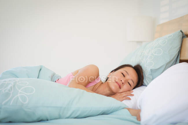 Mulher asiática dormindo na cama pela manhã. estilo de vida, passar o tempo e relaxar em casa. — Fotografia de Stock