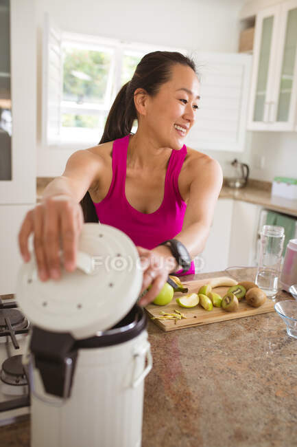 Glückliche asiatische Frau bereitet Smoothie in der Küche zu. gesunder aktiver Lebensstil und Zeit zu Hause verbringen. — Stockfoto