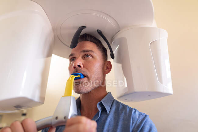 Paciente do sexo masculino, caucasiano, examinando os dentes e tendo raio-x na clínica odontológica moderna. serviços de saúde e odontologia. — Fotografia de Stock