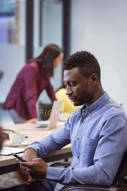 African american disabled businessman using smartphone and sitting in wheelchair in modern office. business and office workplace. — Stock Photo
