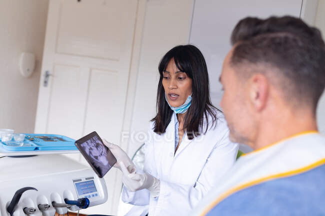 Dentiste de naissance portant un masque facial examinant les dents d'un patient de sexe masculin à la clinique dentaire moderne. soins de santé et de la dentisterie. — Photo de stock