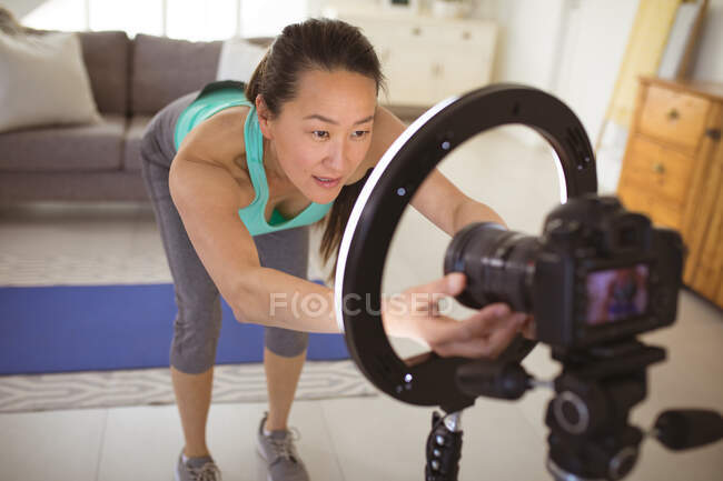 Feliz mulher asiática preparando câmera para fazer fittnes vlog de casa. estilo de vida ativo saudável e fitness em casa com tecnologia. — Fotografia de Stock