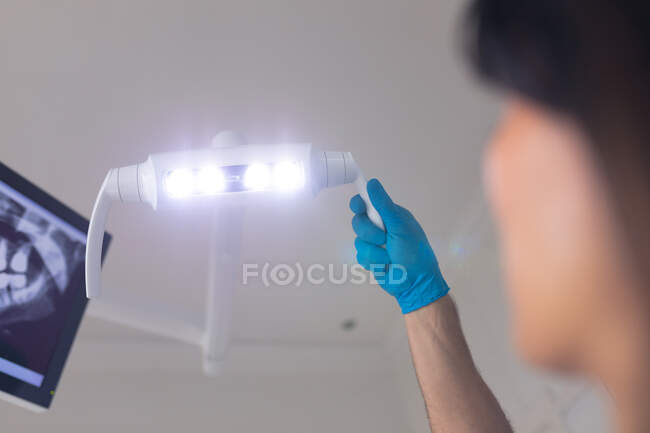Caucasian male dentist holding lamp with examinating teeth of female patient at modern dental clinic. healthcare and dentistry business. — Stock Photo