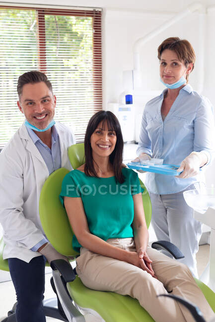 Портрет усміхненого різноманітного стоматолога, стоматолога і пацієнта в сучасній стоматологічній клініці. охорона здоров'я та стоматологічний бізнес . — стокове фото