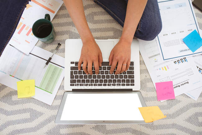 Hände von Frauen, die auf dem Boden sitzen und von zu Hause aus mit Laptop und Kopierraum arbeiten. Home Office und freiberufliches Konzept. — Stockfoto