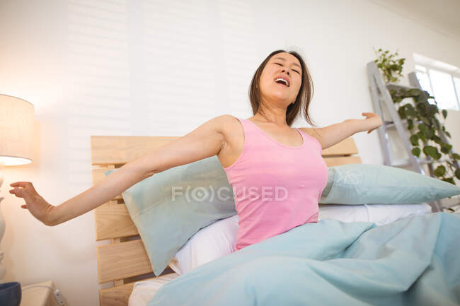 Donna asiatica sdraiata a letto, che si sveglia la mattina. stile di vita, trascorrere del tempo e rilassarsi a casa. — Foto stock