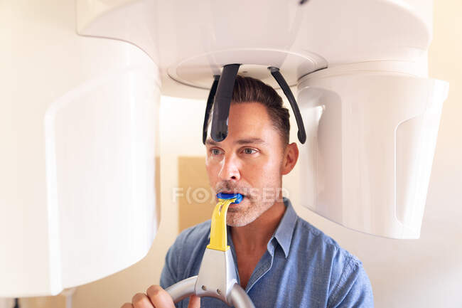 Patient masculin caucasien examinant les dents et ayant une radiographie à la clinique dentaire moderne. soins de santé et de la dentisterie. — Photo de stock