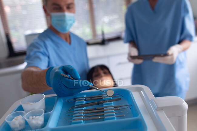 Dentiste caucasien et infirmière dentaire examinant les dents du patient à la clinique dentaire moderne. soins de santé et de la dentisterie. — Photo de stock