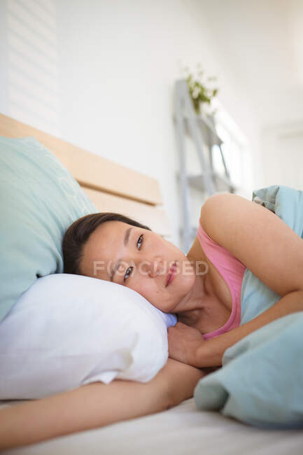 Ritratto di donna asiatica sdraiata a letto, che si sveglia la mattina. stile di vita, trascorrere del tempo e rilassarsi a casa. — Foto stock